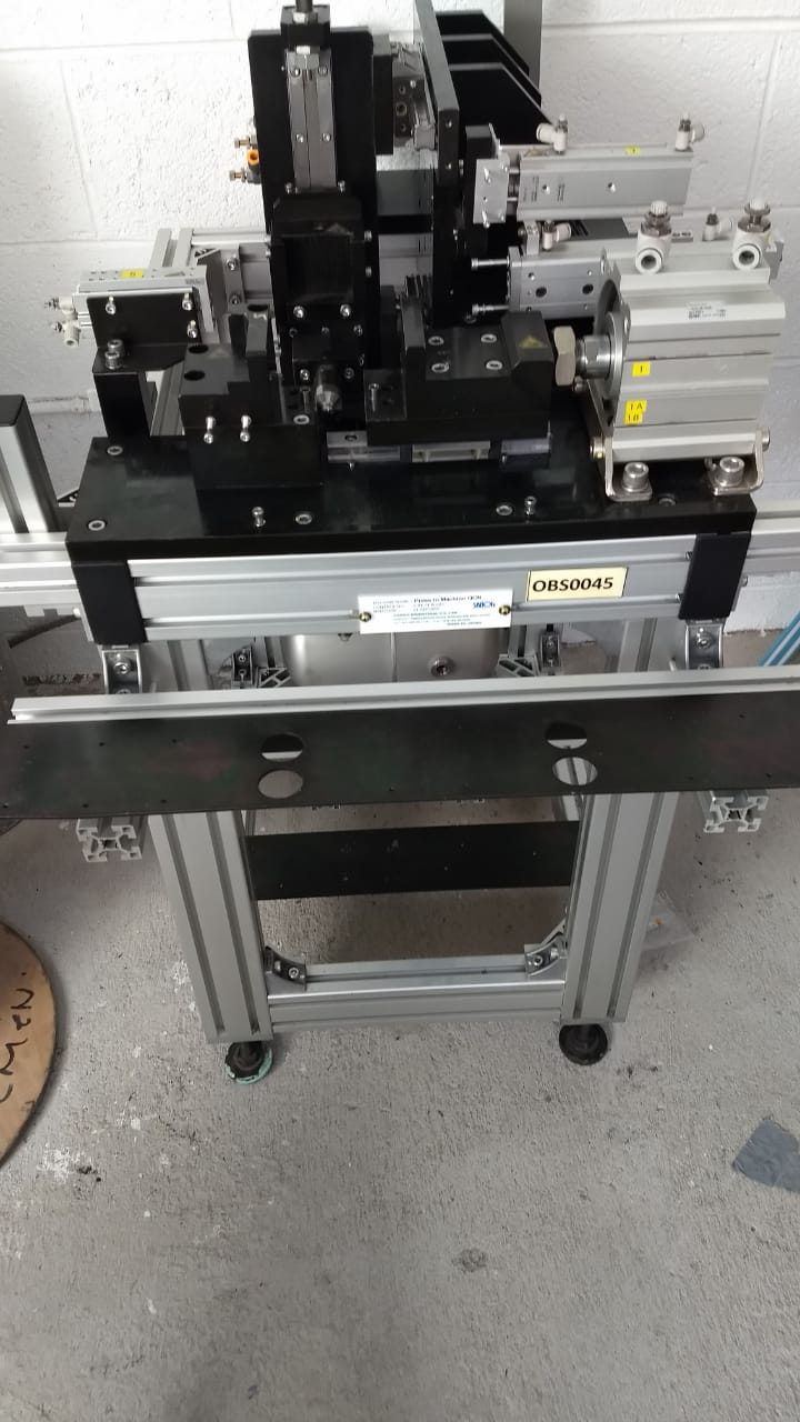 Dispositivo mecánico montado sobre una mesa de perfiles de aluminio.